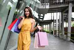 女人持有购物袋消费主义生活方式购物中心