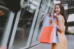 女人持有购物袋消费主义生活方式购物中心