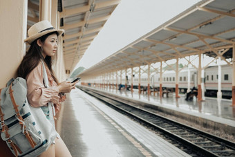 女人旅行者背包移动聪明的电话火车站旅行<strong>旅程</strong>旅行概念