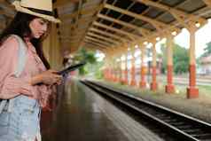 女人旅行者平板电脑火车站旅行旅程旅行概念