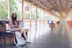 女人旅行者电脑火车站旅行旅程旅行概念