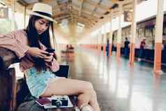 女人旅行者移动聪明的电话火车站旅行旅程旅行概念