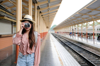 女人旅行者持有相机采取照片火车站旅行旅行旅程