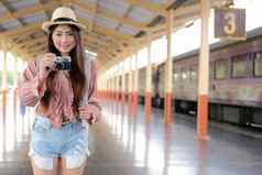 女人旅行者持有相机采取照片火车站旅行旅行旅程