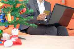 女人持有信贷卡电脑在线购物女商人购买圣诞节礼物互联网一年假期快乐圣诞节庆祝活动
