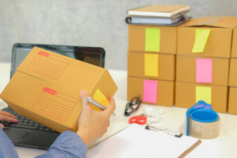 启动业务老板持有纸板盒子女人卖方准备包裹盒子交付在线销售电子商务概念