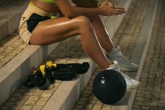 特写镜头照片女人健身穿锻炼重医学球在户外运动女孩适合身体运动服装摆姿势楼梯