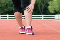 中间岁的女人跑步者肌肉疼痛培训在户外