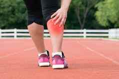 中间岁的女人跑步者肌肉疼痛培训在户外
