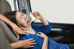 上了年纪的女人令人窒息的持有哮喘喷雾内部车