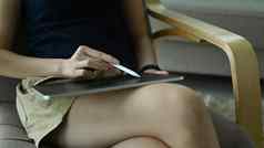 女人持有手写笔笔数字平板电脑坐着扶手椅