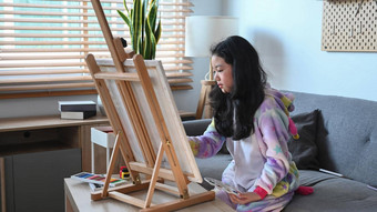 可爱的亚洲女孩绘<strong>画图片</strong>画架生活房间