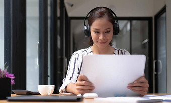 快乐亚洲女人年轻的穿耳机沟通客户端视频电脑调用