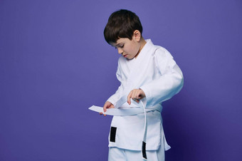 自信欧洲十几岁的男孩把白色和服关系带腰准备好了战斗体育合气道战斗机东方武术艺术