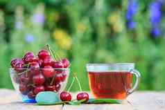 红色的成熟的樱桃水果总花梗玻璃碗杯茶