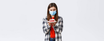 冠状病毒爆发生活方式社会距离假期庆祝活动概念困惑女人医疗面具盯着困惑生日蛋糕基斯蜡烛思考白色背景