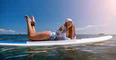 健康的快乐适合女人比基尼放松冲浪板浮动清晰的绿松石海水休闲体育站桨登机夏天有趣的假期旅行活跃的生活方式