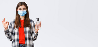 冠状病毒爆发休闲检疫社会距离情绪概念很高兴保证年轻的女人医疗面具推荐买手洗手液品牌显示标志