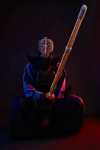 关闭剑道战斗机穿护甲传统的和服头盔坐着练习<strong>武术</strong>艺术shinai竹子剑黑色的<strong>背景</strong>