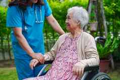 医生亚洲上了年纪的女人残疾病人坐着轮椅公园医疗概念