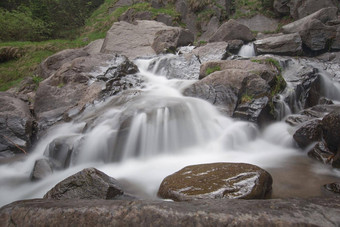 长曝光水流动岩石石头湿干岩石周围水流河