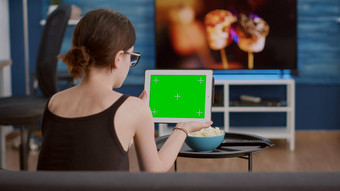 回来视图年轻的女人持有数字平板电脑绿色屏幕看社会媒体视频内容