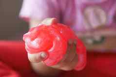 孩子手持有粉红色的颜色黏液