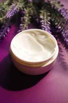 Herbal奶油化妆品容器薰衣草花紫色的背景