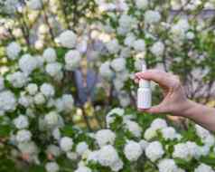 女人的手鼻喷雾背景开花树