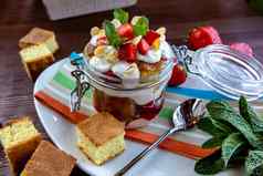 分层甜点巧克力海绵蛋糕生奶油ricotta新鲜的草莓玻璃碗蛋糕美味的美食早餐