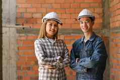 年轻的架构师穿安全头盔站手臂交叉建设网站行业工程师建设概念