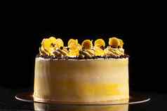 轮黄色的生日蛋糕装饰奶油装饰蛋糕黑色的背景