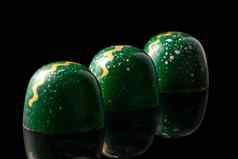 奢侈品手工制作的巧克力糖果黑色的背景绿色糖果五彩缤纷的滴产品概念巧克力制造商