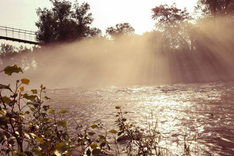 多雾的早....阴霾河条纹阳光悬架人行桥早....健美的图像