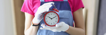 女人工人统一的持有红色的时钟提醒完成工作时间