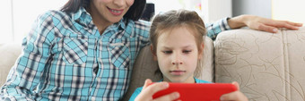 女儿玩在线<strong>视频</strong>游戏智能手机妈妈看