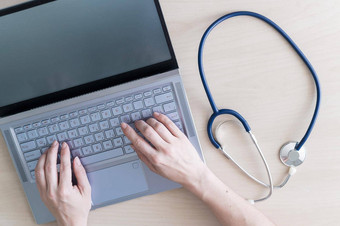 前视图手键盘女人医生桌子上打字移动PC护士填满病人<strong>电子卡</strong>