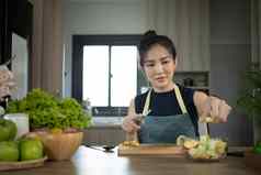 美丽的年轻的女人准备蔬菜沙拉厨房节食健康的吃生活方式概念
