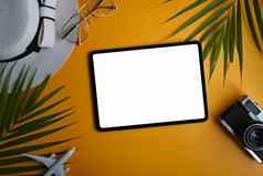 旅行者配件数字平板电脑热带棕榈叶子黄色的背景夏天假期概念