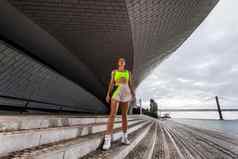 女人健身穿锻炼在户外运动女孩适合身体运动服装摆姿势天空背景