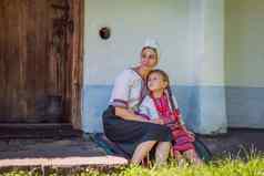 妈妈。女儿坐着房子乌克兰人礼服
