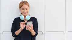 快乐的女人耳机移动电话首页爱好现代无线技术概念