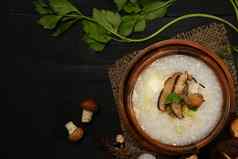 大米粥软煮熟的蛋香菇蘑菇春天洋葱木碗服务表格