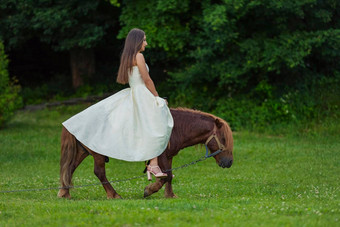 女孩白色衣服骑小马