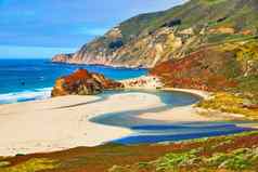 雄伟的蓝色的河海洋海滩满足海洋包围山覆盖春天植物