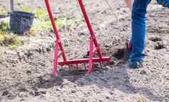 农民牛仔裤挖掘地面红色的叉形铲奇迹铲方便的工具手册cultivatorcultivator非常高效。手工具耕作放松床上