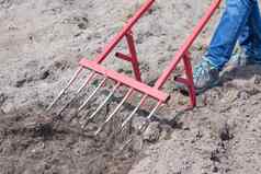 农民牛仔裤挖掘地面红色的叉形铲奇迹铲方便的工具手册cultivatorcultivator非常高效。手工具耕作放松床上