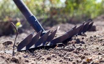 照片花园耙床上金属耙花园春天清洁形成土壤种植耙春天工作花园工具土壤准备播种