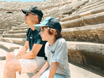 年轻的父亲爸爸学校男孩孩子儿子游客参观古老的古董竞技场圆形露天剧场废墟热夏天一天