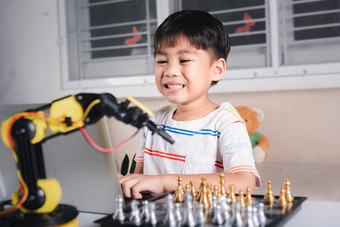 亚洲男孩<strong>编程</strong>代码机器人机手臂移动PC玩国际象棋